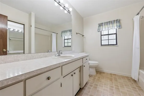 a bathroom with a granite countertop sink toilet and mirror