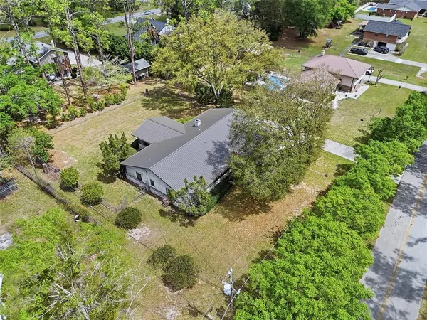 an aerial view of residential house with yard and swimming pool
