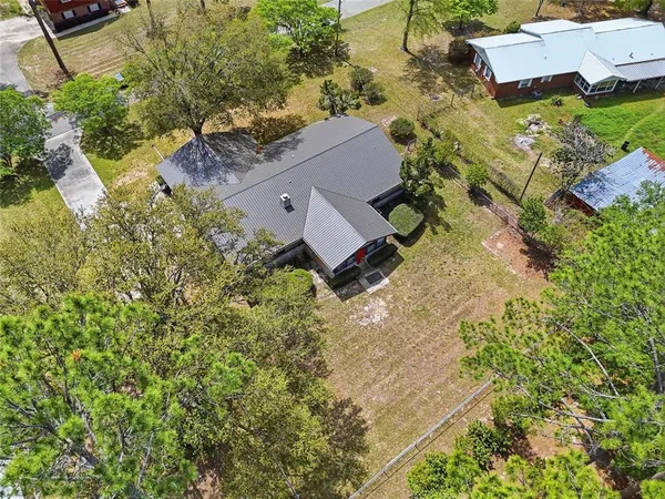 an aerial view of a house with a yard and trees