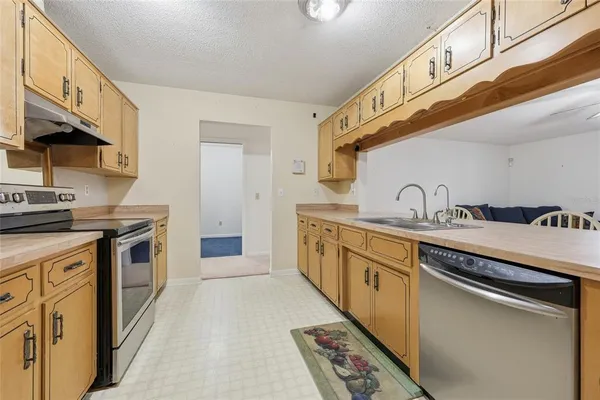 a kitchen with stainless steel appliances granite countertop a sink a stove and a refrigerator