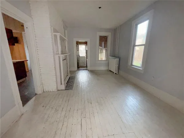 an empty room with windows and wooden floor