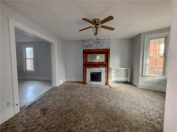 a view of a livingroom with a fireplace and window