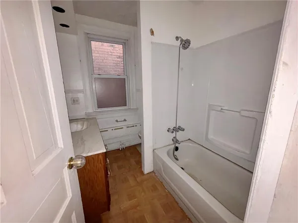 a bathroom with a tub a sink and a mirror