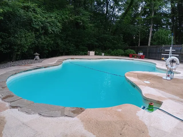 a view of backyard with wooden fence and large trees