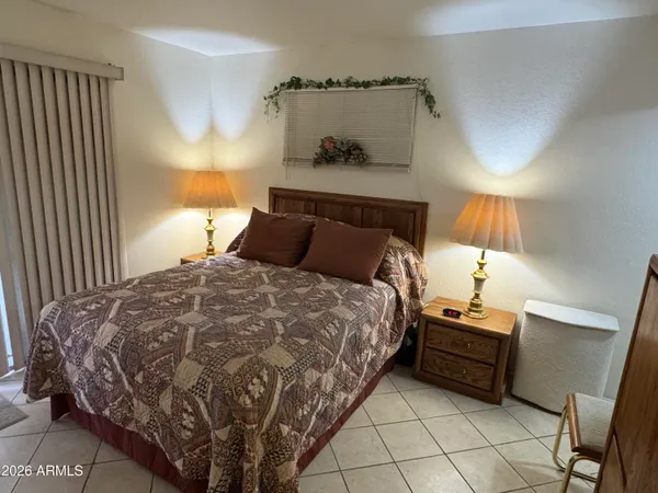 a bedroom with a bed and a lamp on the dresser