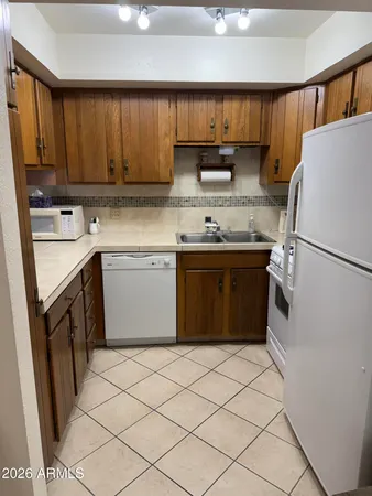 a kitchen with stainless steel appliances granite countertop a sink stove refrigerator and cabinets