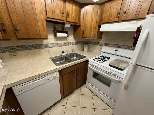 a kitchen with granite countertop a sink stove and microwave