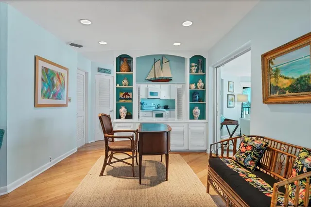a kitchen with stainless steel appliances wooden floor dining table and chairs