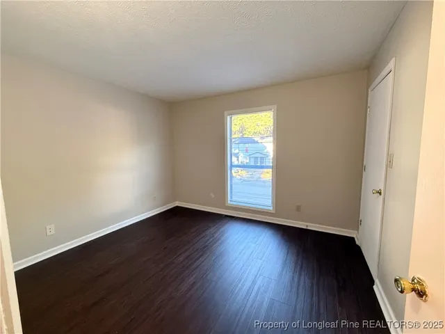 an empty room with wooden floor and window