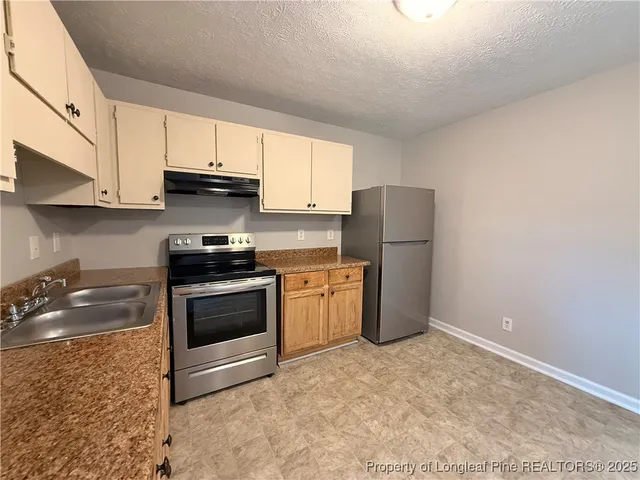 a kitchen with a sink a stove a microwave and cabinets