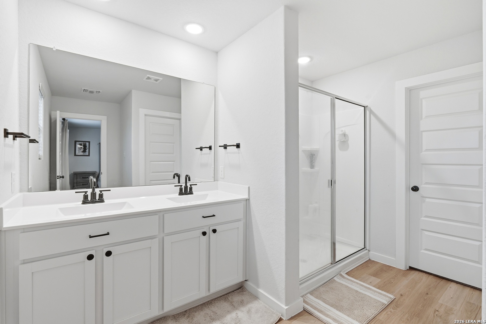 3523 Rancho Grande San Antonio, TX 78224 - Photo 19 of 22 a en suite bathroom with a double vanity sink a mirror and a shower