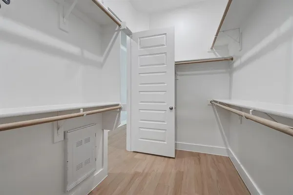 an empty room with wooden floor ceiling fan and windows