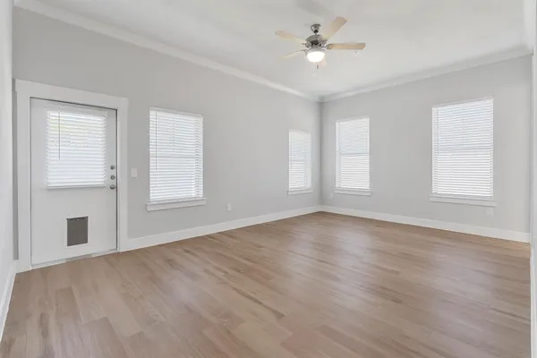 an empty room with wooden floor and window