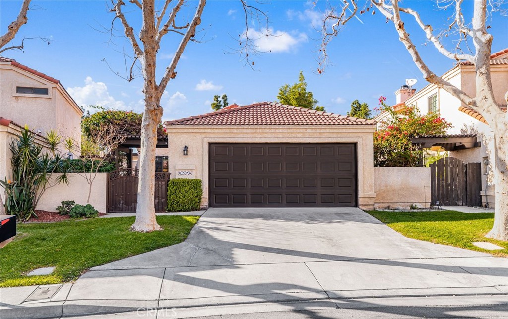 8576 Creekside Place Rancho Cucamonga, CA 91730 - Photo 2 of 37 a view of a house with a small yard plants and a large tree