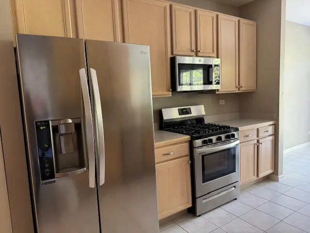 a kitchen with stainless steel appliances granite countertop a refrigerator stove and sink