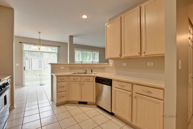 a kitchen with white cabinets appliances and a counter top