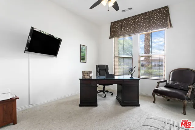 a view of a workspace with furniture and a window