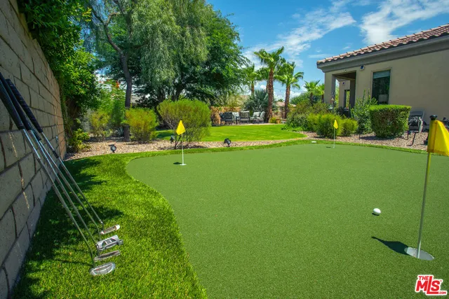 a view of a backyard house with large trees and plants
