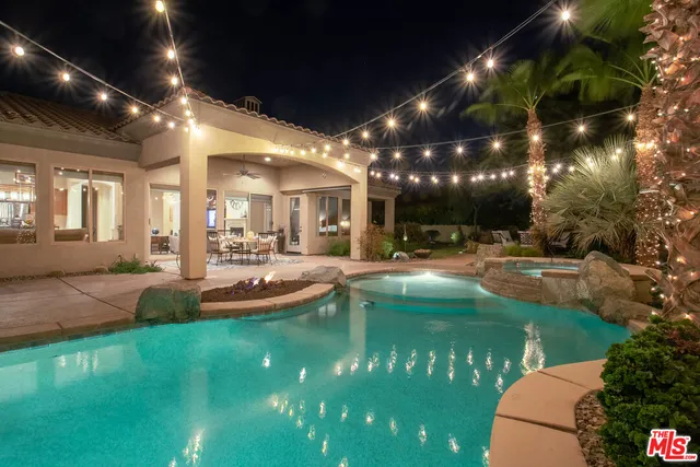 a view of a patio with dining table and chairs with plants and wooden fence