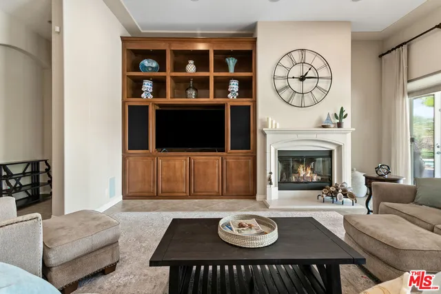 a living room with furniture a clock and a fireplace
