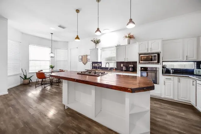 a kitchen with sink stove and microwave