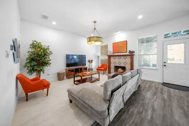 a living room with furniture a fireplace and a flat screen tv