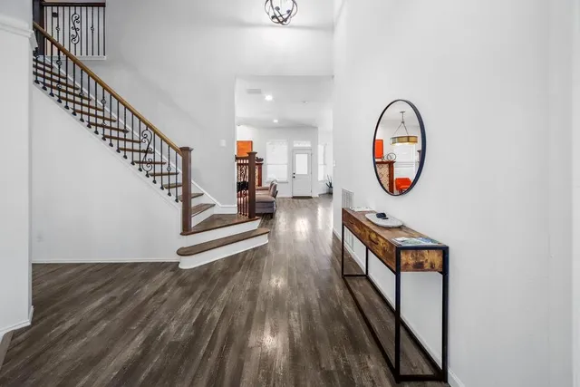 a view of entryway and hall with wooden floor