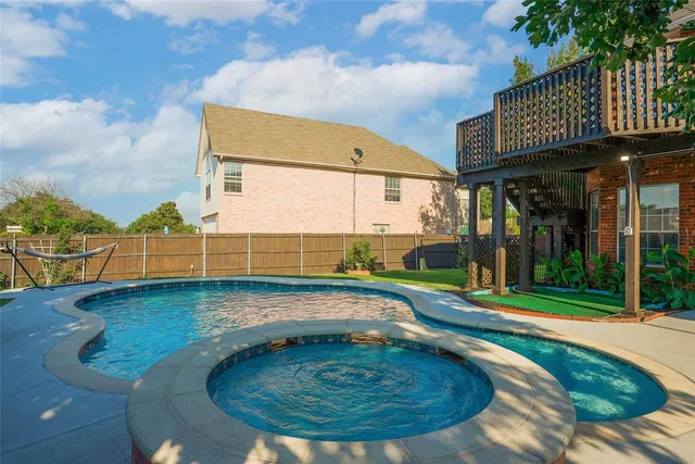 an aerial view of a residential houses with outdoor space and a lake view in back