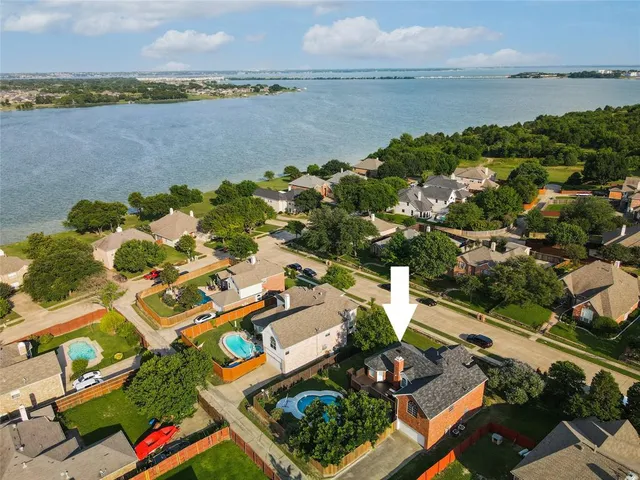 an aerial view of a city with lots of residential buildings ocean and mountain view in back