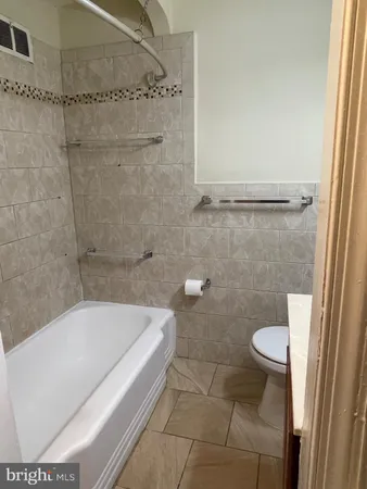 a bathroom with a tub and toilet
