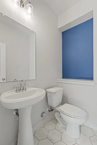 a bathroom with a sink a toilet and mirror