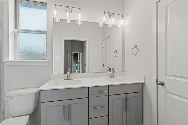 a bathroom with a sink a toilet and a mirror