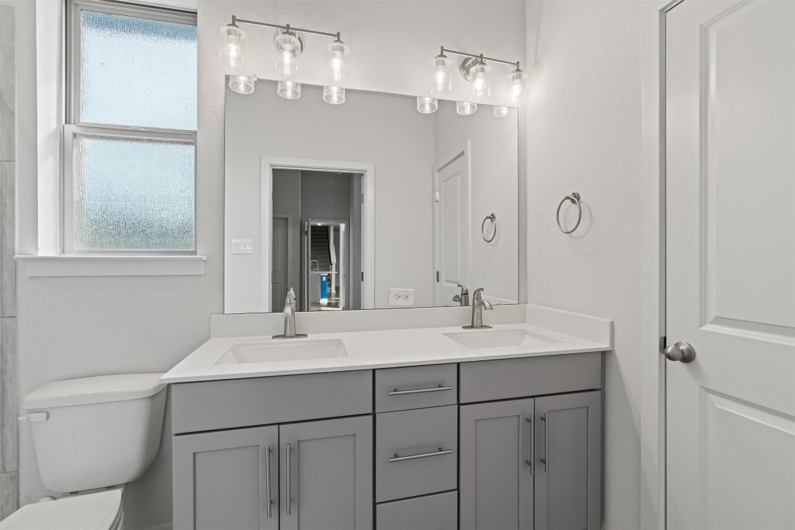 2500 Forest Creek Drive, Unit 302 Round Rock, TX 78665 - Photo 14 of 27 a bathroom with a sink a toilet and a mirror