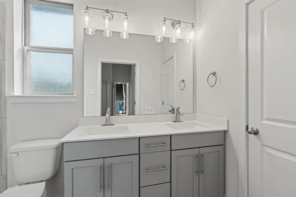 a bathroom with a sink a toilet and a mirror