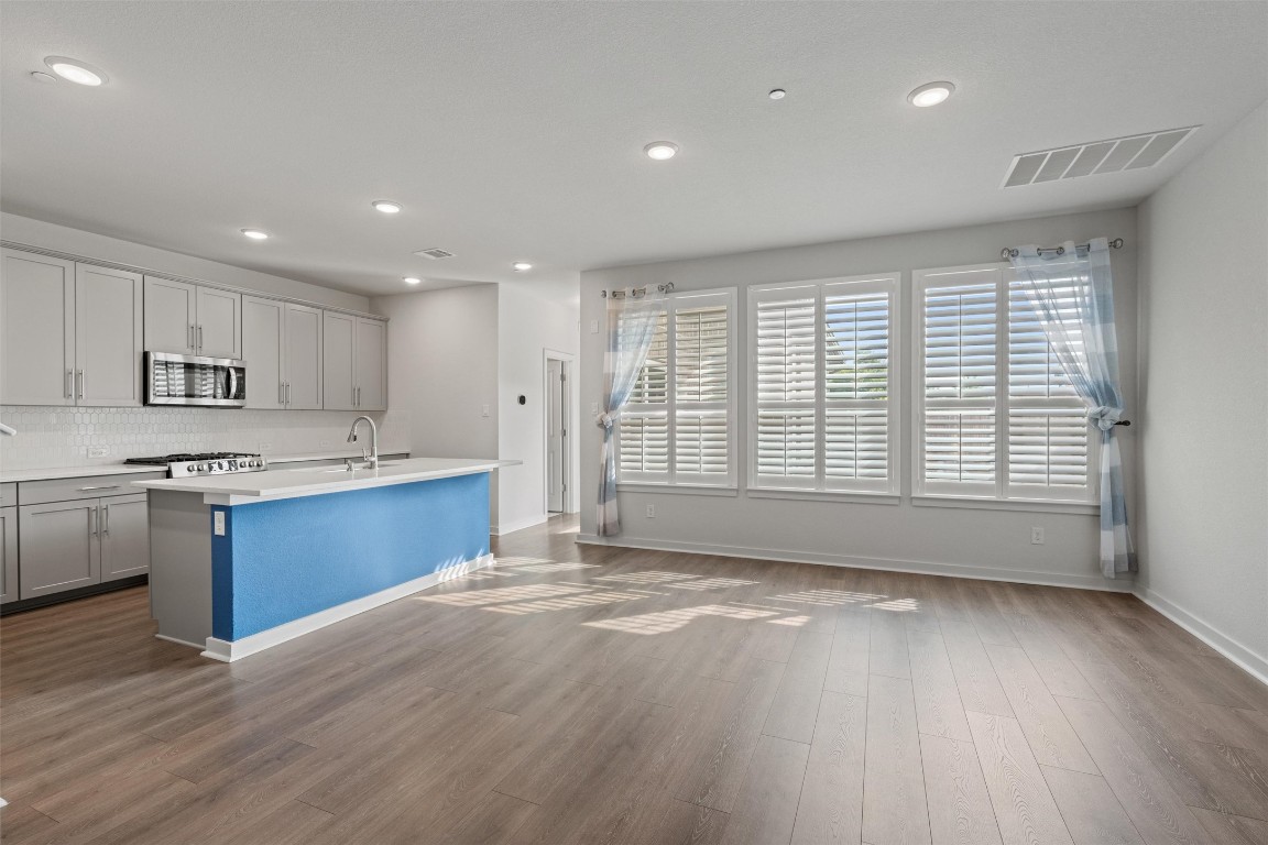 2500 Forest Creek Drive, Unit 302 Round Rock, TX 78665 - Photo 4 of 27 a large kitchen with stainless steel appliances granite countertop a large window a oven and a sink with granite countertops