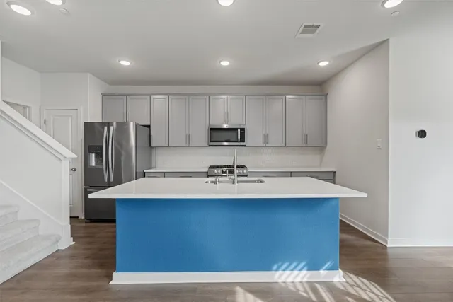 a kitchen with kitchen island a sink appliances and cabinets