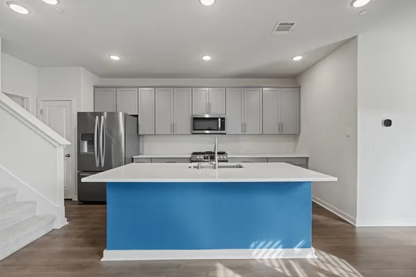 a kitchen with kitchen island a sink appliances and cabinets