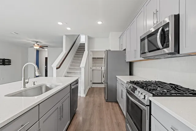 a kitchen with stainless steel appliances granite countertop a sink stove and refrigerator
