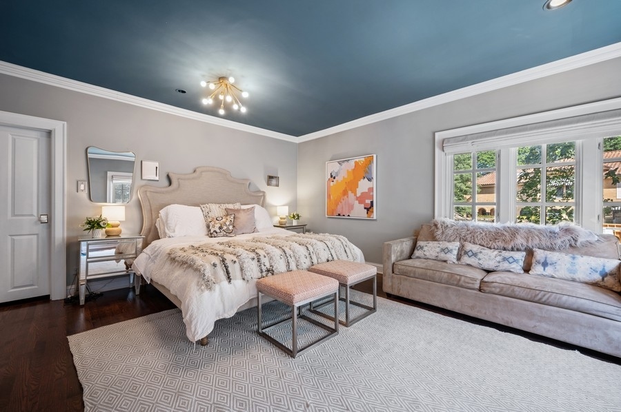 505 Ridge Road Kenilworth, IL 60043 - Photo 12 of 26 a spacious bedroom with a bed and a chandelier