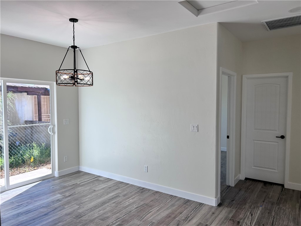 1266 Wilson Road Bullhead City, AZ 86442 - Photo 13 of 29 Unfurnished dining area with wood finished floors and a chandelier