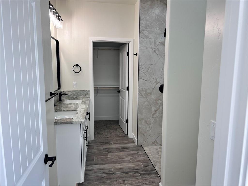1266 Wilson Road Bullhead City, AZ 86442 - Photo 18 of 29 Full bath with double vanity, a walk in closet, and wood tiled floors