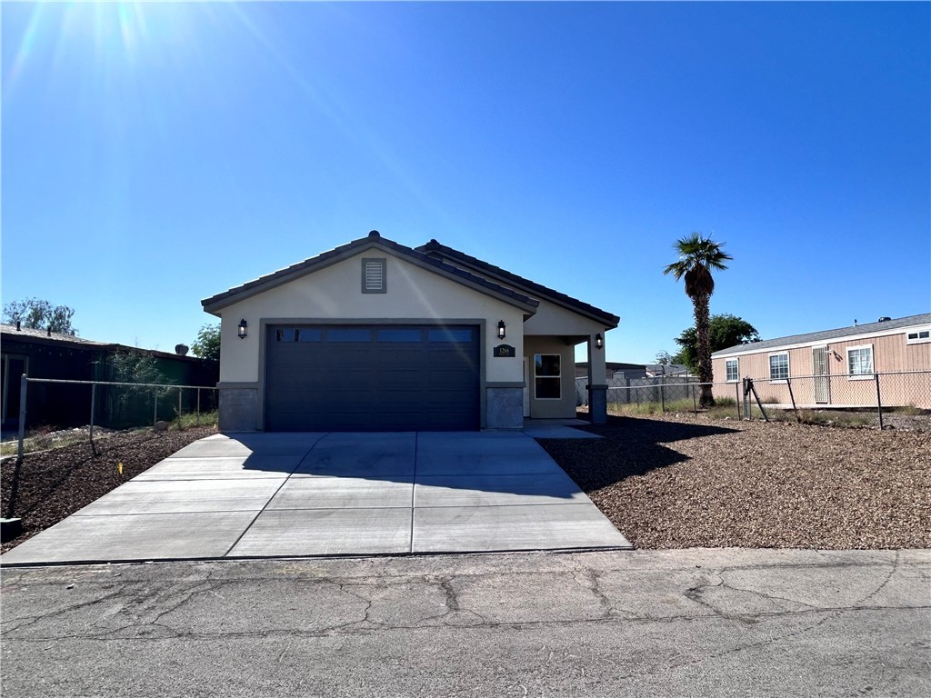 1266 Wilson Road Bullhead City, AZ 86442 - Photo 2 of 29 View of front of property with stucco siding, driveway, and a garage