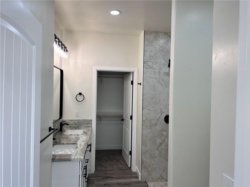 1266 Wilson Road Bullhead City, AZ 86442 - Photo 19 of 29 Bathroom with double vanity, a walk in closet, dark wood finished floors, and recessed lighting