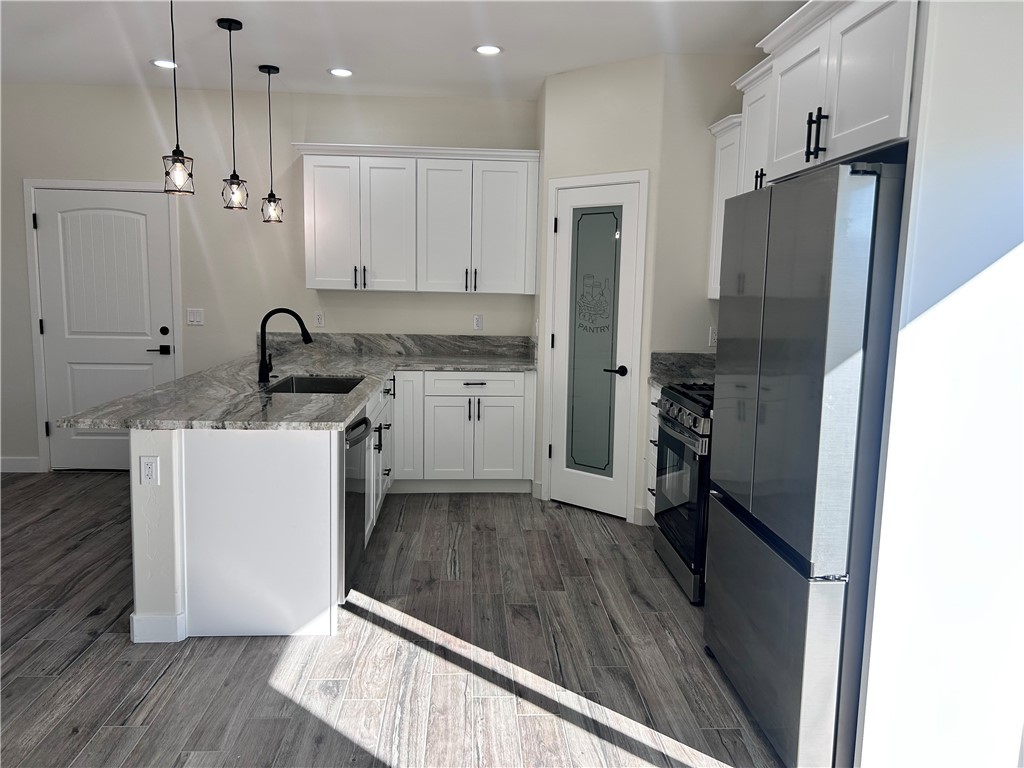 1266 Wilson Road Bullhead City, AZ 86442 - Photo 5 of 29 Kitchen featuring white cabinetry, black appliances, a peninsula, decorative light fixtures, and recessed lighting