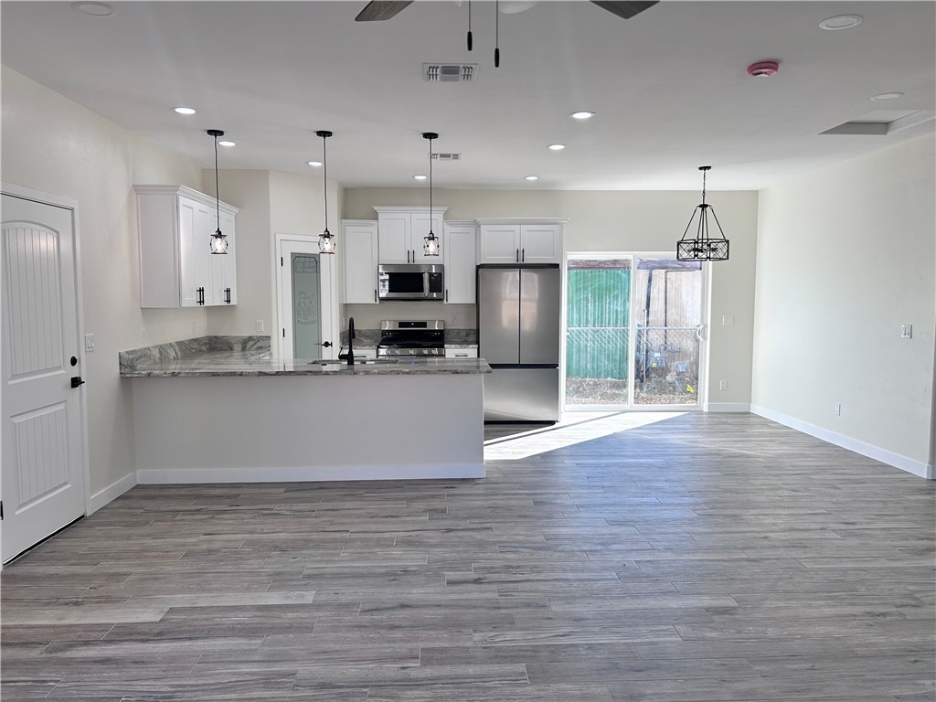 1266 Wilson Road Bullhead City, AZ 86442 - Photo 28 of 29 Kitchen with open floor plan, white cabinets, recessed lighting, appliances with stainless steel finishes, and a peninsula