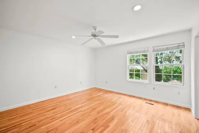 an empty room with a window and a fan