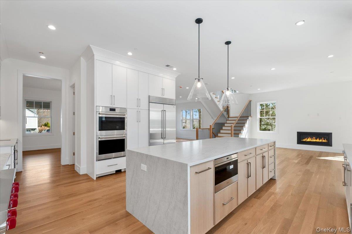 8 Dell Road Scarsdale, NY 10583 - Photo 12 of 41 a large kitchen with stainless steel appliances a large center island attached withe living room