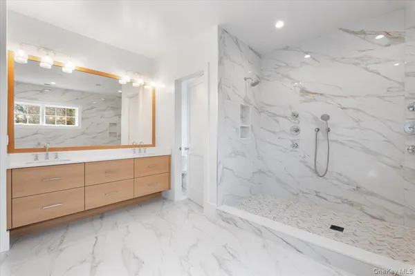 a bathroom with a granite countertop sink a mirror a bathtub and shower