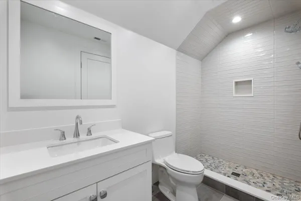a bathroom with a sink a toilet and a mirror