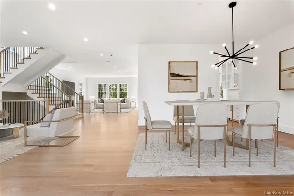 a view of a dining room and livingroom with furniture wooden floor a chandelier